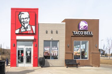 Calgary, Alberta, Kanada. 23 Aralık 2025. İki markalı KFC ve Taco Bell restoranının sokak seviyesinde çekimleri, her bir bayilik için farklı tabela ve mimari tarzlar içeriyor..