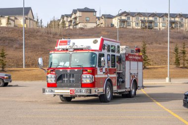Calgary, Alberta, Kanada. 23 Aralık 2025. Kırmızı ve beyaz Calgary İtfaiye Departmanı itfaiye aracının önden görüntüsü asfalt bir alana park edilmiş ve arka planda konut binaları görülebiliyor..