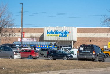 Calgary, Alberta, Kanada. 5 Nisan 2025. Açık bir günde kalabalık bir otoparkın üstündeki cephede logosu olan bir toptancı kulübünün dış görünüşü..