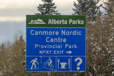 Canmore, Alberta, Kanada. 4 Nisan 2025. Alberta Parks 'taki Canmore Nordic Centre İl Parkı' nın yol kenarı tabelası bir sonraki çıkışı gösteriyor. Ayrıca kros kayağı için piktogramlar da gösteriliyor.