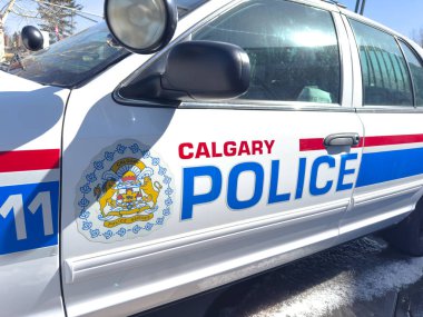 Calgary, Alberta, Kanada. 8 Nisan 2025. Calgary Polis Servisi aracının yakın çekiminde resmi arma ve beyaz vücudunda mavi ve kırmızı çizgili 