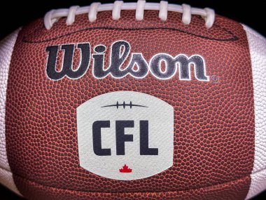 Calgary, Alberta, Kanada. 8 Nisan 2025. Yakın plan çekimde beyaz bağcıklı kahverengi Wilson futbolu ve akçaağaç yaprağı logosu sergileniyor..