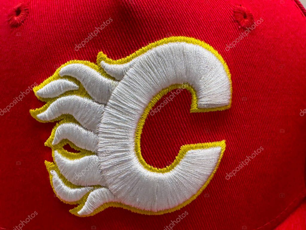 Calgary, Alberta, Canada. Apr 8, 2025. A close-up features the Calgary Flames hockey team logo, a stylized white letter 'C' with yellow and red flame accents, embroidered on a red surface.