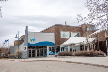 Calgary, Alberta, Kanada. 13 Nisan 2025. Bow Habitat İstasyonu ve Sam Livingston Balık Yetiştirme Tesisi. Ayırt edici işareti ve bayrakları olan modern tuğla ve gri bir bina..