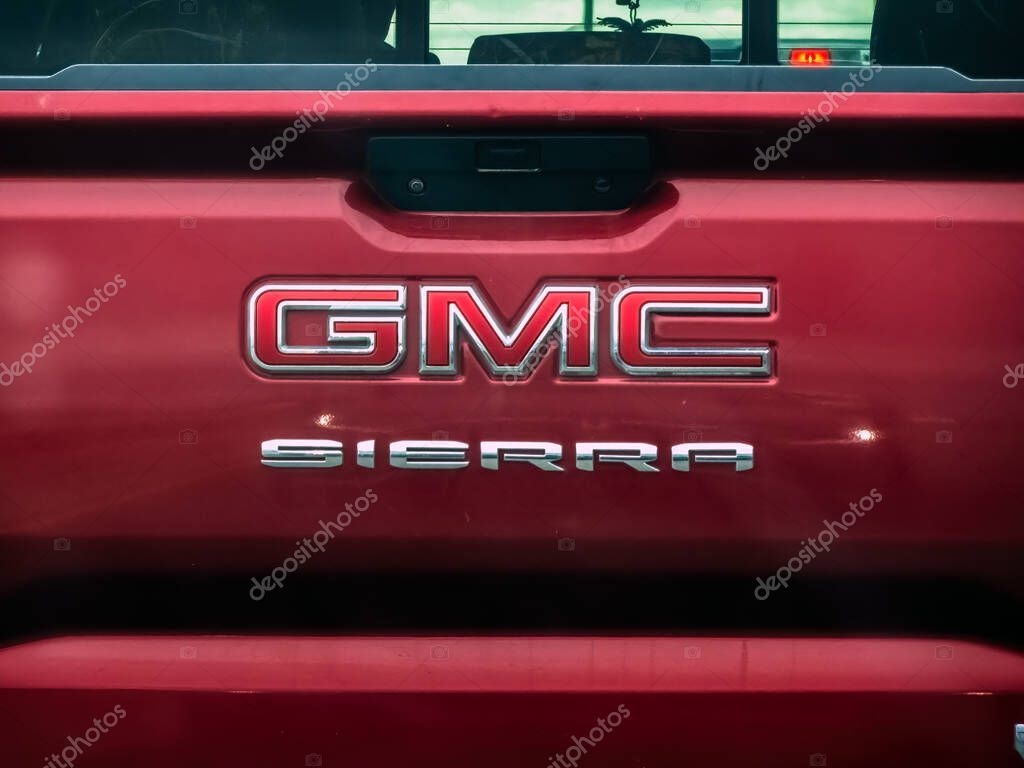 Calgary, Alberta, Canada. Apr 13, 2025. A close-up shows the rear of a red GMC Sierra truck, highlighting the chrome 