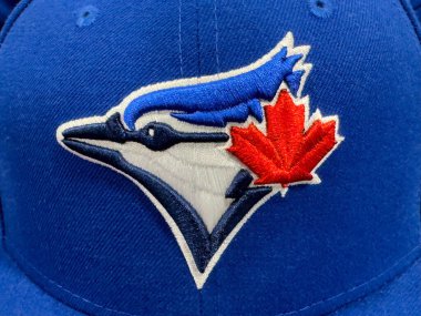 Calgary, Alberta, Kanada. 17 Nisan 2025. Toronto Blue Jays beyzbol takımının logosuna yakın plan, mavi bir alakarga ve akçaağaç yaprağı, mavi bir şapka üzerinde.