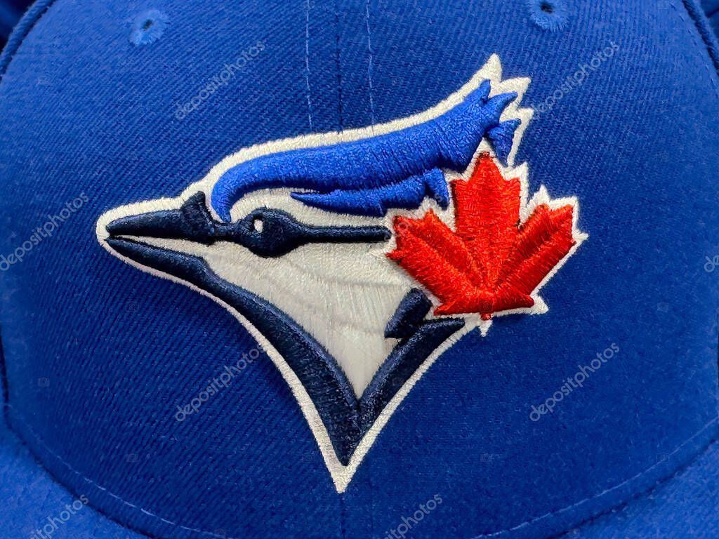 Calgary, Alberta, Canada. Apr 17, 2025. A close-up of the Toronto Blue Jays baseball team logo, featuring a blue jay and maple leaf, on a blue cap.