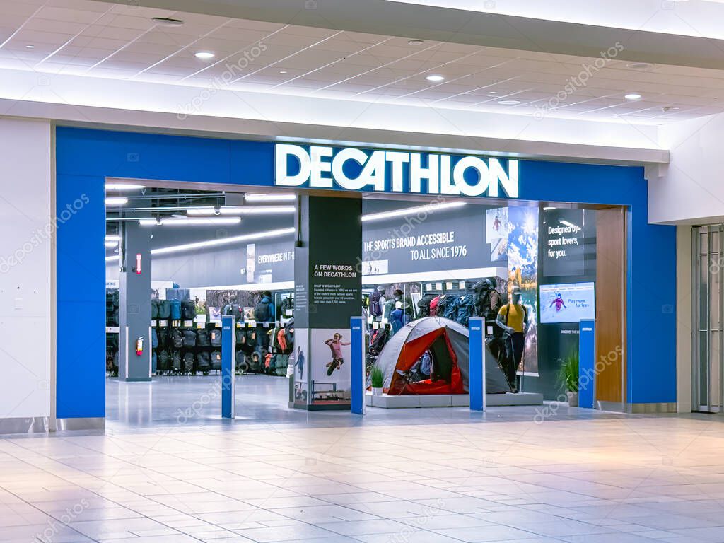 Calgary, Alberta, Canada. Apr 17, 2025. A Decathlon retail store entrance displays outdoor gear, apparel, and sports equipment under bright modern lighting in a shopping mall.