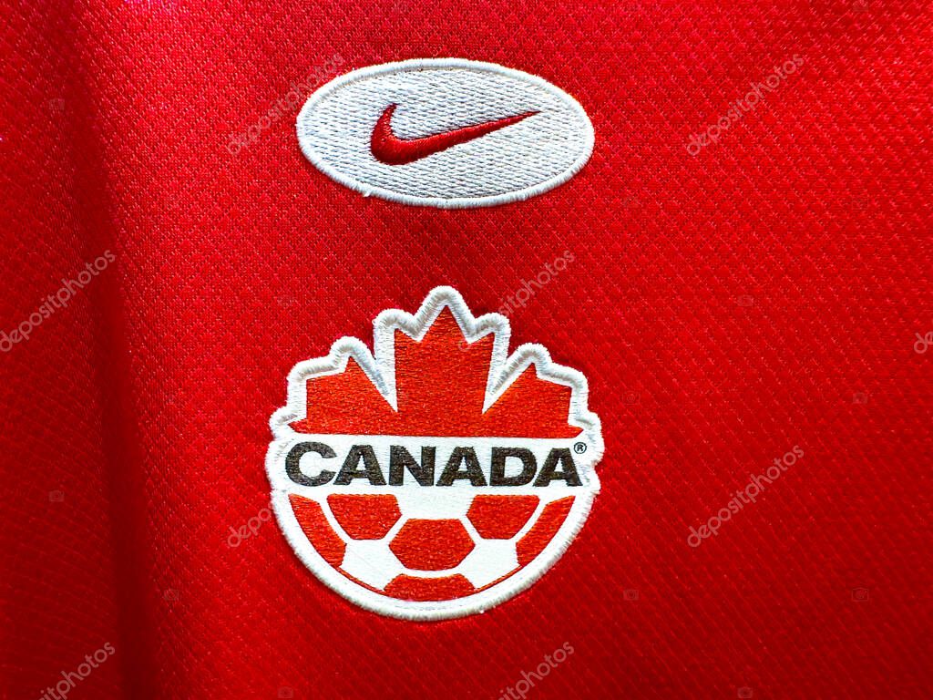 Calgary, Alberta, Canada. Apr 17, 2025. A close-up of the Canada Soccer logo (maple leaf and soccer ball) and a Nike swoosh emblem on a red sports fabric.