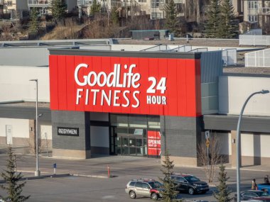 Calgary, Alberta, Kanada. 18 Nisan 2025. GoodLife Spor Merkezi 'nin dış cephesinde 24 saat açık olduğunu gösteren beyaz harfli belirgin bir kırmızı tabela var..