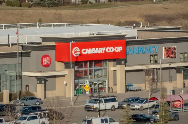 Calgary, Alberta, Kanada. 18 Nisan 2025. Calgary, Alberta 'da güneşli bir günde eczanesi ve otoparkı olan bir Calgary kooperatifi..