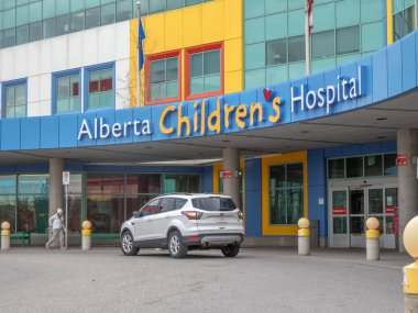 Calgary, Alberta, Kanada. 24 Nisan 2025. Alberta Çocuk Hastanesi mavi ve sarı cepheleriyle resmedilmiş ve hastanenin adı belirgin bir şekilde sergilenmiştir..