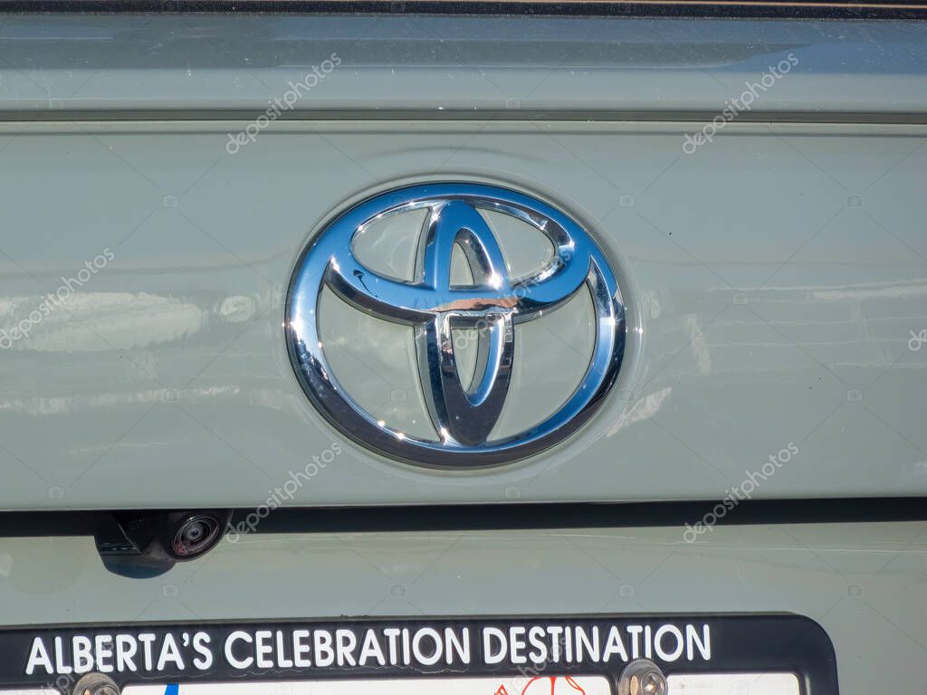 Calgary, Alberta, Canada. Apr 28, 2025. A close-up shows the chrome Toyota logo on a light green vehicle, above an Alberta license plate frame.