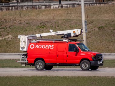 Calgary, Alberta, Kanada. 4 Mayıs 2025. Kırmızı Rogers servis aracı Calgary, Alberta 'da bir yolda. Rogers logosu yan tarafta belirgin bir şekilde sergileniyor.