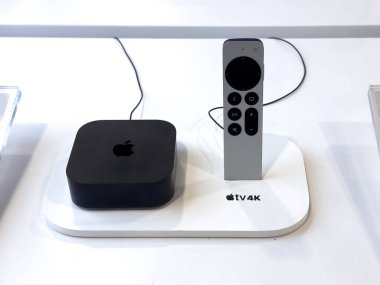 Calgary, Alberta, Kanada. 4 Mayıs 2025. Bir Apple TV ve uzaktan kumandası sergileniyor. Siyah Apple TV kutusu beyaz bir üste duruyor, gümüş kumanda hemen yanında duruyor..