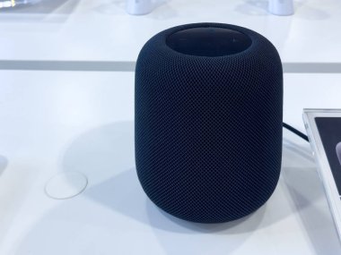 Calgary, Alberta, Kanada. 4 Mayıs 2025. Koyu renkli bir Apple HomePod beyaz bir yüzeyde oturur..