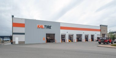 Calgary, Alberta, Kanada. 9 Mayıs 2025. Geniş açı Calgary, Alberta 'da bir Kal Tire otomotiv servis merkezini çekiyor, bulutlu bir gökyüzünün altında, birden fazla servis ambarı ve park edilmiş araçları gösteriyor..