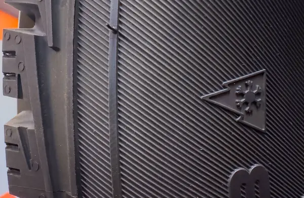 Calgary, Alberta, Kanada. 12 Mayıs 2025. Lastik izinin yakın plan çekimi, oyukların altını çizmek ve üç tepeli dağ kar tanesinin (3PMSF) simgesi.