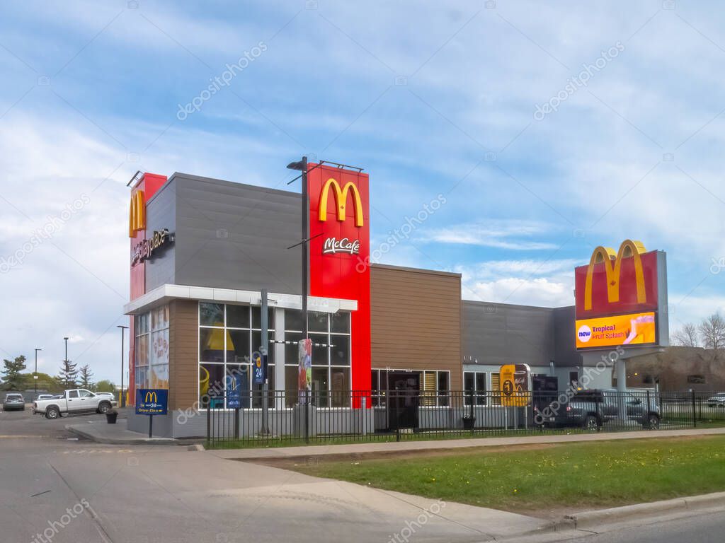 Calgary, Alberta, Canada. May 15, 2025. The familiar golden arches of a McDonald's restaurant stand prominently in Calgary, complete with a McCafe section and drive-thru.