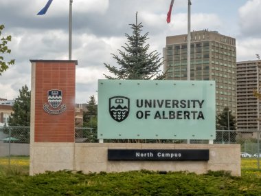 Edmonton, Alberta, Kanada. 20 Mayıs 2025. Alberta Üniversitesi Kuzey Kampüsü 'ne giriş. Bulutlu bir gökyüzünün altında belirgin işareti ve arması akademik mükemmelliği sembolize ediyor..