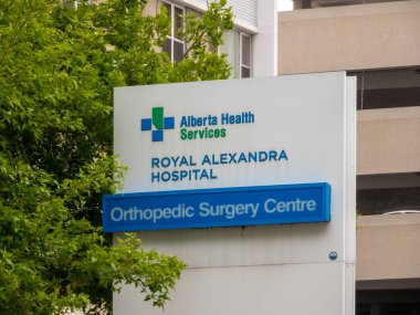 Edmonton, Alberta, Kanada. 21 Mayıs 2025. Alberta Sağlık Hizmetleri tabelası, bir kentsel ortamda yemyeşil çerçeveli Royal Alexandra Hastanesi ve Ortopedi Cerrahi Merkezi 'ni gösteriyor.