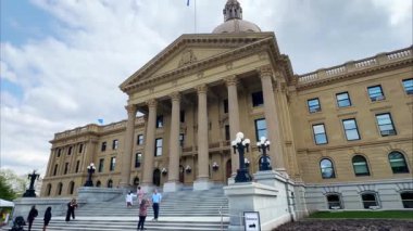 Edmonton, AB, Kanada. 22 Mayıs 2025. Alçak bir açıdan çekilen Alberta Yasama Binası bulutlu gökyüzünün altında büyük cephesini, sütunlarını ve kubbesini sergiliyor..