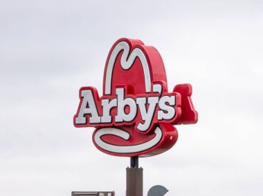Edmonton, Alberta, Kanada. 24 Mayıs 2025. Arby 'nin ikonik kırmızı ve beyaz 10 galonluk şapka logosu bulutlu bir gökyüzüne karşı duruyor ve müşterileri rosto biftekleriyle bilinen fast food zincirine çağırıyor..