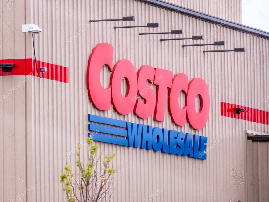 Edmonton, Alberta, Canada. May 24, 2025. Costco Wholesale's iconic red and blue logo stands prominently on a corrugated building, signaling a retail giant's presence.