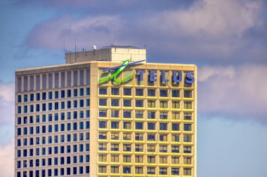 Edmonton, Alberta, Kanada. 27 Mayıs 2025. Telus Evi bulutlu bir gökyüzüne karşı duruyor ve çok katlı bir şehir binasının tepesinde ikonik markasını sergiliyor..
