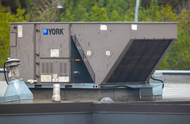Edmonton, Alberta, Kanada. 27 Mayıs 2025. Çatıdaki ticari bir York HVAC ünitesi, modern binalarda ve kentsel altyapıda iklim kontrolü açısından hayati önem taşıyan endüstriyel verimliliği vurguluyor..