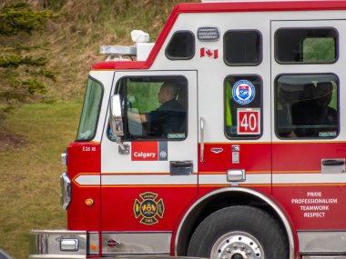 Calgary, Alberta, Kanada. 27 Mayıs 2025. Şehrin amblemi ve Kanada bayrağının yer aldığı pırıl pırıl Calgary İtfaiyesi kamyonu, adanmışlık ve profesyonelliği gözler önüne seriyor..