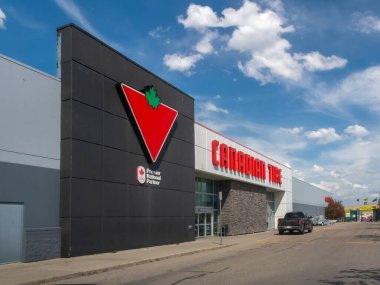 Calgary, Alberta, Kanada. 27 Mayıs 2025. Modern bir Kanada Lastiği mağazası ikonik kırmızı üçgeni ve akçaağaç yaprağı logosuyla Kanada perakende satışının köşe taşını sembolize ediyor..