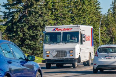 Calgary, Alberta, Kanada. 8 Haziran 2025. Bir Purolator dağıtım kamyonu Calgary 'de ağaçlık bir caddede geziniyor. Etkili paket ve kurye hizmetlerini sembolize ediyor..