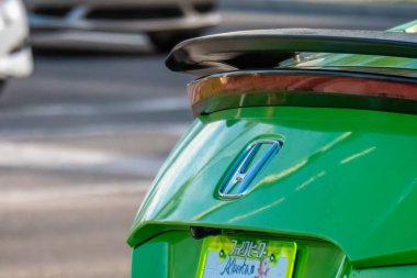 Calgary, Alberta, Canada. Jun 8, 2025. A close-up of a vibrant green Honda Civic's rear, featuring a distinct spoiler and personalized Alberta license plate, highlighting automotive customization.