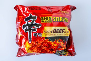 Calgary, Alberta, Kanada. 14 Haziran 2025. Koyu kırmızı Nongshim Shin Ramyun Karıştır Kızartma Eriştesi, baharatlı sığır eti aromalı, temiz, düzensiz beyaz arka planda..