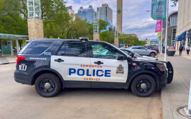 Edmonton, Alberta, Kanada. 12 Haziran 2025. Edmonton Polis Teşkilatı 'ndan bir SUV şehir sokaklarında park halinde, polisin markasını şehir binalarının önünde sergiliyor, görev için hazır..