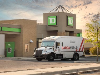 Calgary, Alberta, Kanada. 11 Haziran 2025. Bir TD Bank şubesinin önüne park etmiş GardaWorld zırhlı kamyonu güvenli nakit lojistik ve finansal güvenlik hizmetlerini vurguluyor..
