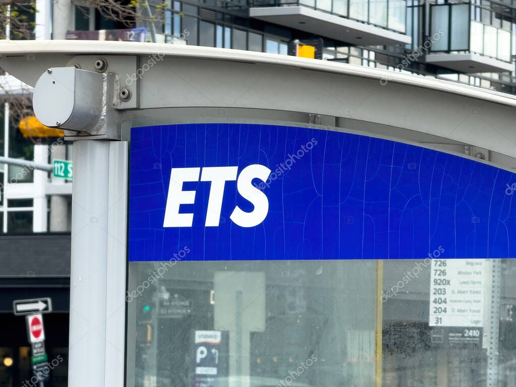 Edmonton, Alberta, Canada. Jun 12, 2025. A clear shot of an ETS (Edmonton Transit System) bus stop sign in an urban setting, featuring the distinctive blue and white logo.