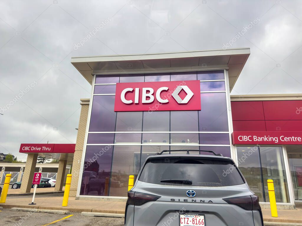 Calgary, Alberta, Canada. Jun 11, 2025. A contemporary CIBC banking center with a prominent logo, featuring a drive-thru and a car parked in front, reflecting modern financial accessibility.