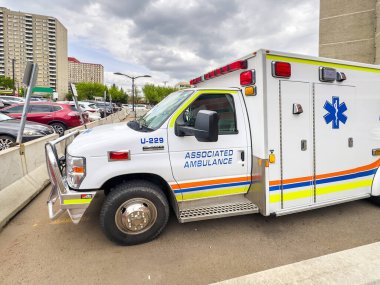 Edmonton, Alberta, Kanada. 17 Haziran 2025. Acil durum müdahalesine hazır bir ambulans aracı, çok sayıda park halinde, kentsel bir ortamda hayati sağlık hizmetlerini ön plana çıkarıyor..