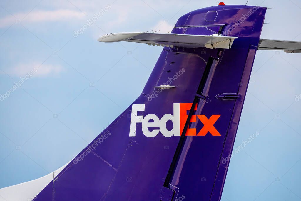 Calgary, Alberta, Canada. Jun 15, 2025. A sharp close-up on the vibrant purple tail of a FedEx Express cargo plane, clearly displaying the iconic orange 