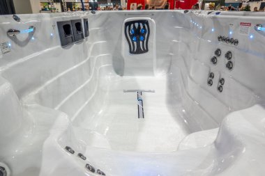 Calgary, Alberta, Kanada. 7 Temmuz 2025. Çoklu jetlerle parıldayan beyaz bir kaplıca ve lüks ev refahını ön plana çıkaran modern bir tasarım..