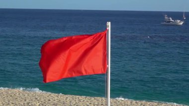 Meksika 'daki Cabo plajında kırmızı uyarı dalgaları mavi okyanus ve Meksika' daki Baja California Sur 'da bulunan teknelere karşı tehlikeli yüzme koşullarının sinyallerini veriyor..