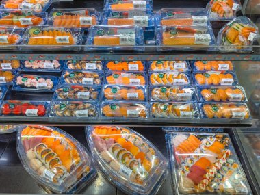 Calgary, Alberta, Kanada. 19 Ağustos 2025. T ve T süpermarketinde hazır suşi ve sashimi sunumu. Dondurulmuş kutuda taze ve yemeye hazır seçenekler sunuyor..