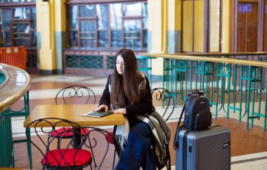 Cafe Table 'da bavullu güzel bir kadın bekliyor. Yüksek kalite fotoğraf