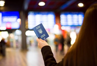 Arka plandaki Tren İstasyonu Planlı Kadın El 'de Ukrayna Biyometrik Pasaportu. Yüksek kalite fotoğraf
