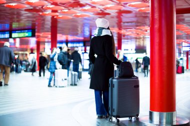  Şık bayan gezgin tren saatlerini kontrol ediyor, seyahat ve ulaşım temaları için ideal... yüksek kaliteli fotoğraf