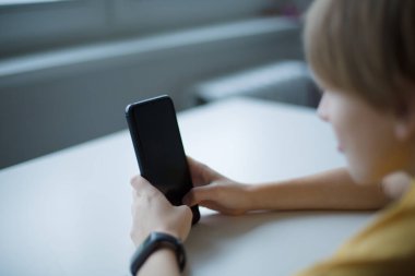 Teknolojiye dalmış akıllı telefon kullanan bir çocuk. Dijital, eğitim ya da iletişim kavramları için mükemmel. Yüksek kalite fotoğraf.