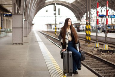 Bavullu Kadın Tren Platformu 'nda Raylı Arka planda Duruyor. Yüksek kalite fotoğraf