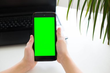 Sade yeşil ekranlı akıllı bir telefon, el ele tutuşmuş, çeşitli düzenleme amaçları için kullanışlı. Yüksek kaliteli fotoğraf..